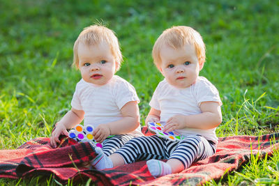 Portrait of siblings sitting on lawn