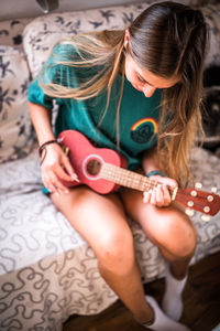 High angle view of woman playing ukulele