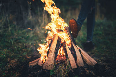 Low section of person standing by bonfire