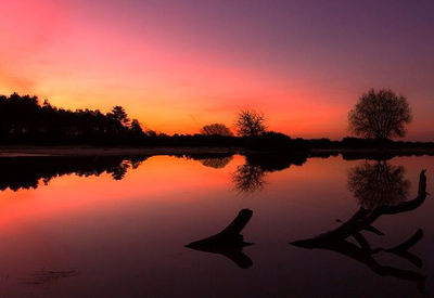 Scenic view of lake against sky at sunset