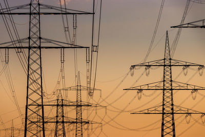 Electricity pylon against sky during sunset