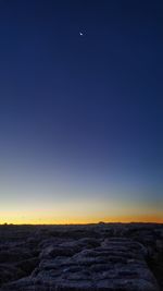 Scenic view of landscape against clear sky at sunset