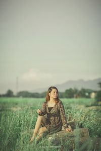 Portrait of a young woman sitting on land