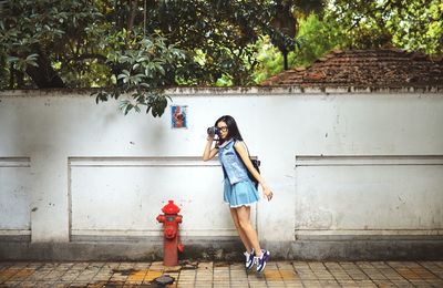 Full length of woman standing on tree trunk