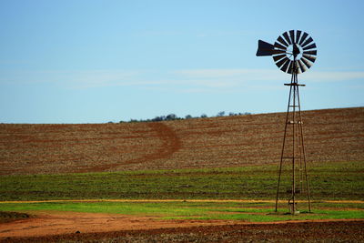 Windmill on field against sky