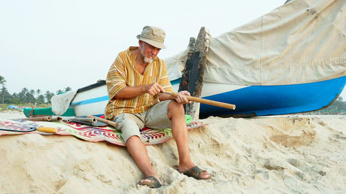 Midsection of man sitting on beach