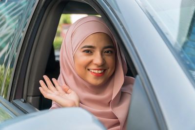 Portrait of a smiling young woman in car