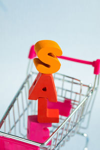 Close-up of pink toy on railing against sky