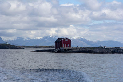 Building by lake against sky