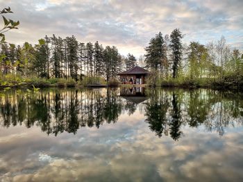 Scenic view of lake by trees against sky