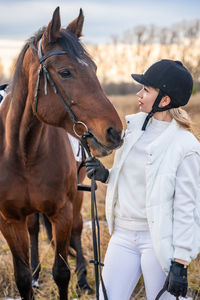 Rear view of man riding horse on field