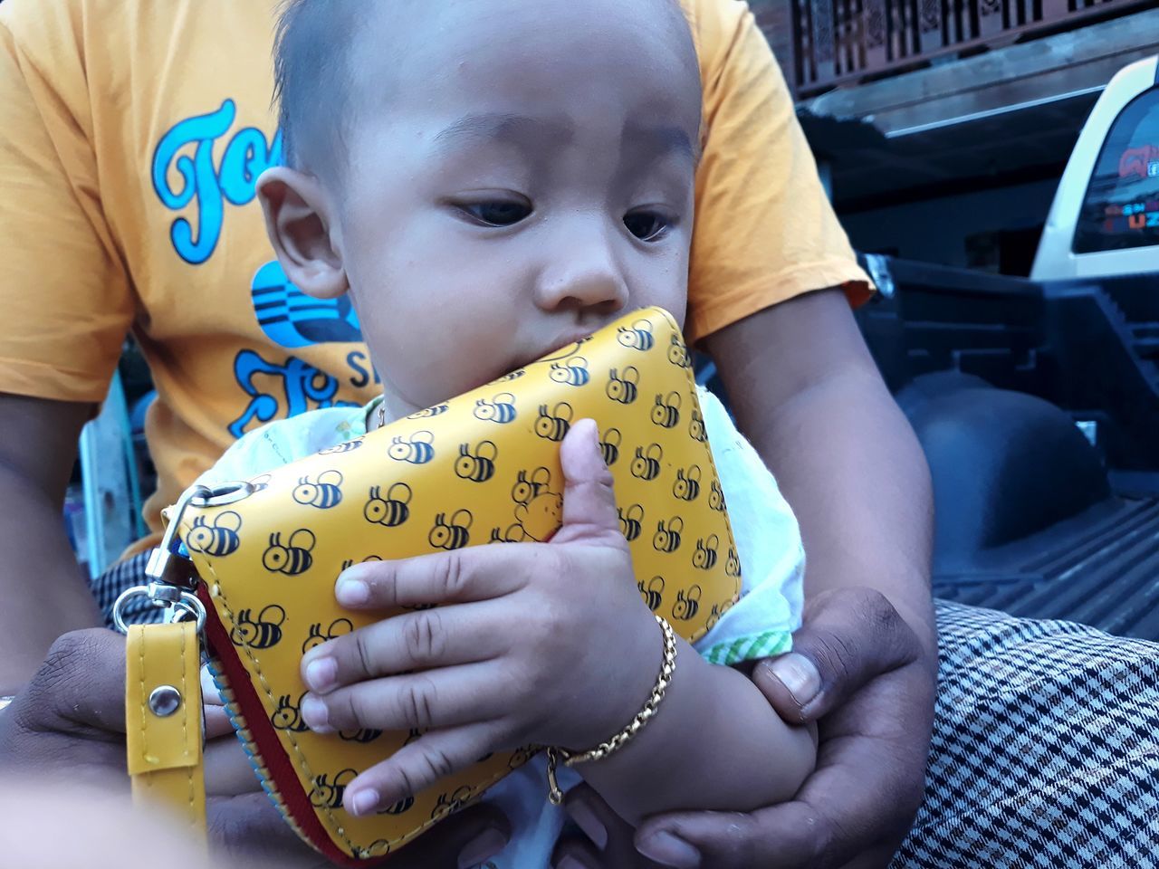 CLOSE-UP OF CUTE BABY GIRL WITH YELLOW CAR