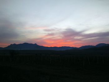 Scenic view of silhouette field against sky during sunset