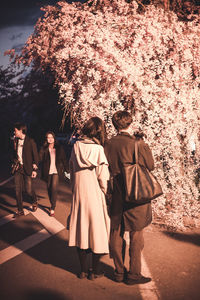 Rear view of people standing against plants