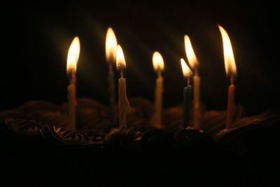 Close-up of lit candle in dark room