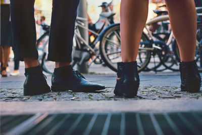 Low section of man and woman standing on footpath