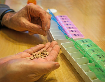 Cropped hand holding pills by pill box