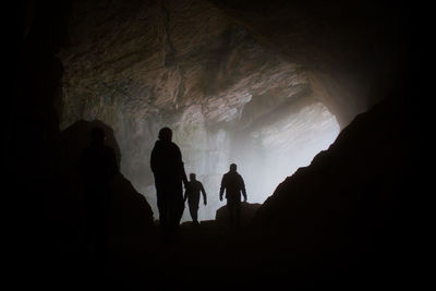 Silhouette men in cave