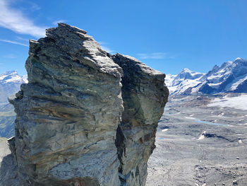 Scenic view of snowcapped mountains against blue sky