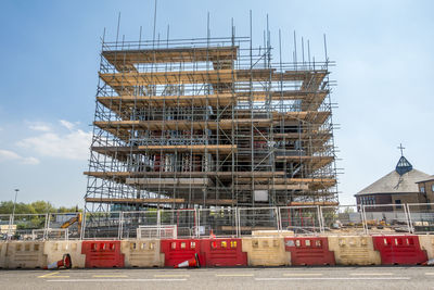 Low angle view of construction site against sky in city