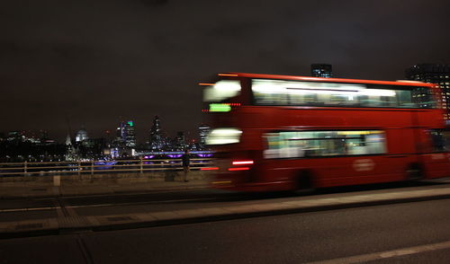 Blurred motion of illuminated city against sky at night