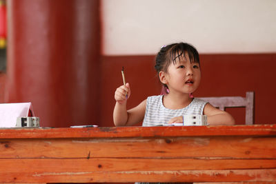 Cute girl looking away on table