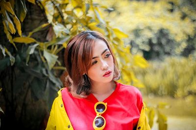 Close-up of young woman looking away while standing at park