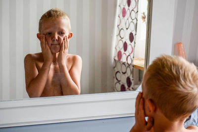 Portrait of shirtless boy in bathroom