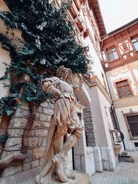 Low angle view of statue against building in city