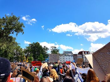 Group of people in city against sky