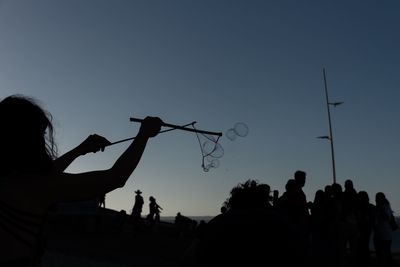 Rear view of people against clear sky