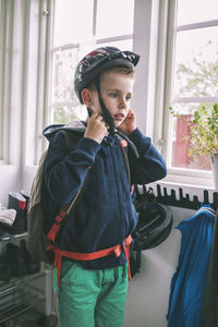 Boy wearing cycling helmet at home