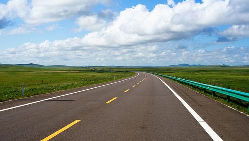 Empty road along countryside landscape