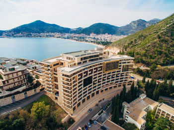 High angle view of city by sea against sky