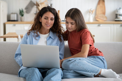 Friends using laptop at home