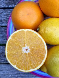 Close-up of halved and whole oranges in plate