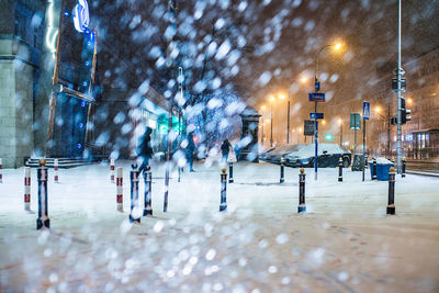 People in snow covered city at night