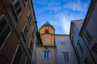 Low angle view of clock tower amidst buildings in city