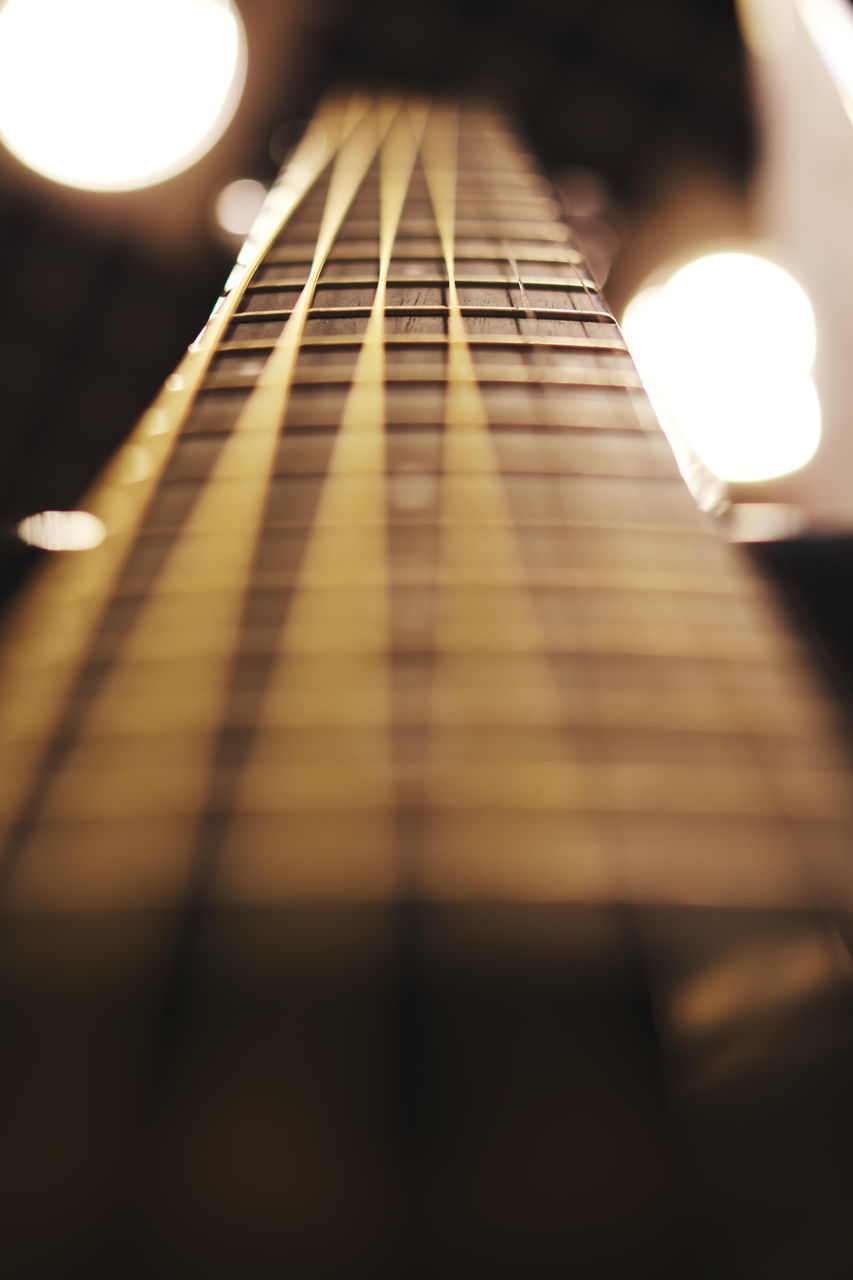 music, musical instrument, string instrument, musical equipment, guitar, string, musical instrument string, selective focus, arts culture and entertainment, close-up, indoors, fretboard, no people, still life, illuminated, wood - material, acoustic guitar, pattern, woodwind instrument, sheet music