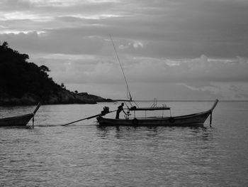 Fishing boat in sea against sky