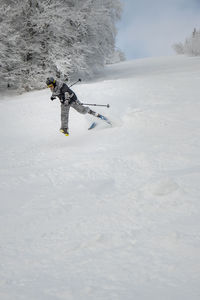 Man skiing on snow covered field