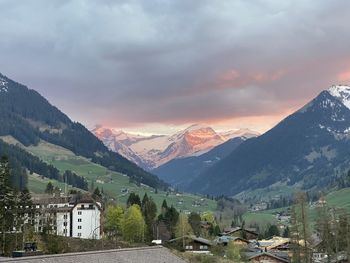 Aerial view of townscape by mountains against sky