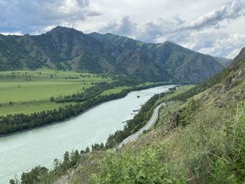 Scenic view of river amidst mountains against sky