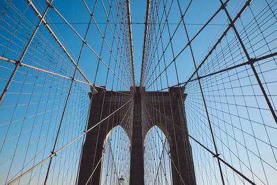 Low angle view of brooklyn bridge against clear blue sky in city