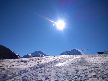 Scenic view of snowcapped mountains against sky on sunny day