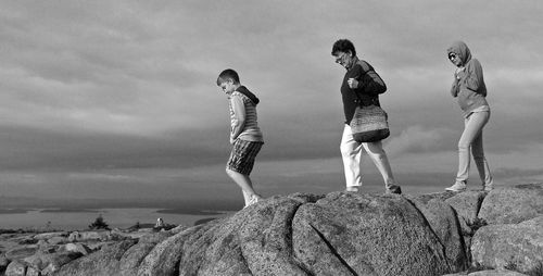 Friends standing on field against sky