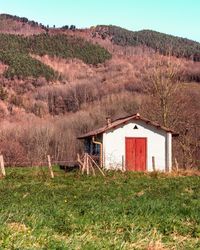 House on field against mountain