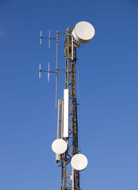 Low angle view of communications tower against sky