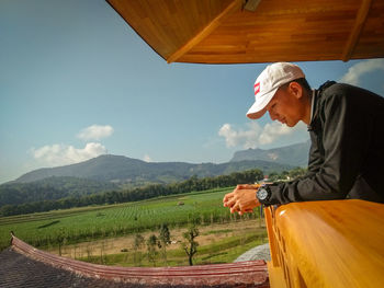 Side view of teenage boy on observation point against landscape