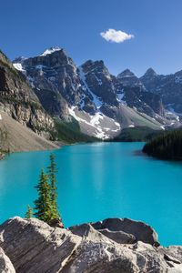 Scenic view of lake by mountains against blue sky